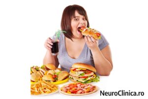 Hiperfagie (mâncat compulsiv): persoană consumând cantități mari de fast-food