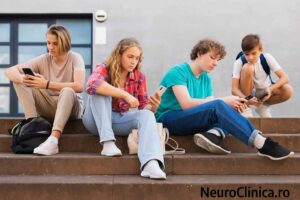 Adolescenți stând împreună pe trepte, fiecare concentrat pe telefonul mobil, simbolizând izolarea socială în era digitală.